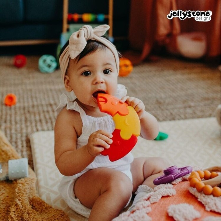 Dziewczynka gryzie silikonowy segment puzzli Jellystone &ndash; bezpieczna zabawka do ząbkowania